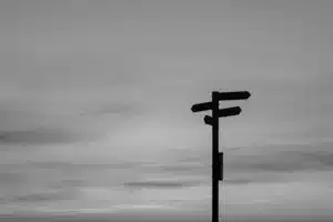 Black and white image of a signpost pointing in multiple directions, symbolizing agency strategic decisions in the age of AI