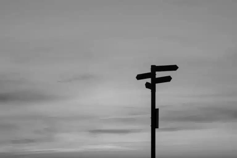 Black and white image of a signpost pointing in multiple directions, symbolizing agency strategic decisions in the age of AI