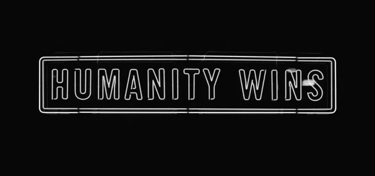 Neon sign reading “Humanity Wins,” representing Bravery Group’s human-centered M&A strategy focused on empathy and trust