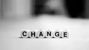 Stacked dice spelling “CHANGE” representing reevaluating investment banks’ role in M&A